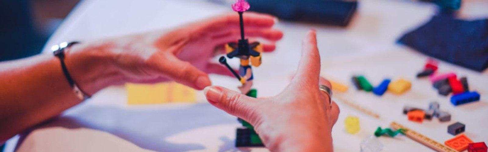 Handen die een toren bouwen met Lego Serious Play